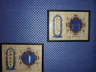 Blaue strukturierte Tapete mit geometrischem Muster und gerahmten Wandbildern.